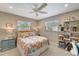 Cozy bedroom with dual windows, colorful bedding, and a decorative display shelf at 1515 Pecan St, Nokomis, FL 34275
