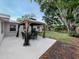 Spacious backyard featuring a patio with gazebo, green lawn, and mature trees at 161 Suntan Ave, Sarasota, FL 34237