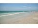 Peaceful beach view with soft waves gently lapping on the shore and clear skies, offering a serene coastal experience at 161 Suntan Ave, Sarasota, FL 34237