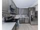 Modern kitchen features stainless steel appliances, gray cabinets, and mosaic tile backsplash at 161 Suntan Ave, Sarasota, FL 34237