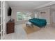 Bright living room featuring a comfortable blue sofa, wood floors, and large windows at 161 Suntan Ave, Sarasota, FL 34237
