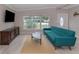 Inviting living room with wood floors, a stylish blue sofa, and plenty of natural light at 161 Suntan Ave, Sarasota, FL 34237