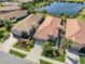 Aerial view of a neighborhood featuring meticulously landscaped homes with a central lake at 165 Tiziano Way, North Venice, FL 34275