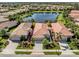 Aerial view of home features lush landscaping and a serene lake, offering privacy and curb appeal at 165 Tiziano Way, North Venice, FL 34275