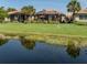 Beautiful backyard featuring a pond, green grass, and a screened-in patio, perfect for outdoor relaxation at 165 Tiziano Way, North Venice, FL 34275