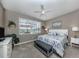 Serene main bedroom with ceiling fan, large window overlooking the lake and comfortable furnishings at 165 Tiziano Way, North Venice, FL 34275