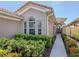 Side view of a home with lush landscaping, an arched entryway, and a tile roof at 165 Tiziano Way, North Venice, FL 34275
