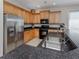 Spacious kitchen with stainless steel refrigerator and black appliances, and speckled countertops at 165 Tiziano Way, North Venice, FL 34275