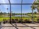 Screened lanai offering tranquil views of the lake and meticulously maintained green space at 165 Tiziano Way, North Venice, FL 34275