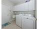 Functional laundry room with white cabinetry, washer, dryer, and utility sink for added convenience at 165 Tiziano Way, North Venice, FL 34275