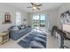 Cozy living room with ceiling fan and sliding glass doors providing lake views and natural light at 165 Tiziano Way, North Venice, FL 34275