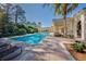 This pool features neatly arranged lounge chairs, palm trees, and a view of the clubhouse at 165 Tiziano Way, North Venice, FL 34275