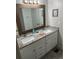 Bathroom features a double sink vanity with granite countertops and white cabinets at 202 Mantua Dr, Venice, FL 34285