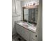 Bathroom features a double sink vanity with granite countertops and white cabinets at 202 Mantua Dr, Venice, FL 34285