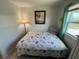 Comfortable bedroom with tropical themed quilt and lots of natural light at 202 Mantua Dr, Venice, FL 34285