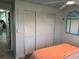 Bedroom featuring multiple closets, a turquoise accent mirror, and natural light at 202 Mantua Dr, Venice, FL 34285