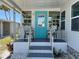 Welcoming front porch with a blue door, seating, and stylish decor enhancing the home's curb appeal at 202 Mantua Dr, Venice, FL 34285