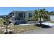 Inviting single-story home featuring a charming porch, well-maintained landscaping, and a palm tree at 202 Mantua Dr, Venice, FL 34285