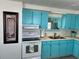Bright kitchen featuring stylish blue cabinets, a double basin sink, and modern appliances at 202 Mantua Dr, Venice, FL 34285