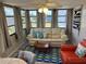 Bright sunroom boasts a cream sofa, red chair, and blue accents at 202 Mantua Dr, Venice, FL 34285