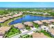 Beautiful aerial view of a residential community with stunning lake, lush greenery, and well-manicured lawns at 21649 Avon Park Ct, Venice, FL 34293