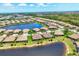 Expansive aerial view of a lovely neighborhood surrounding a serene lake with verdant landscaping at 21649 Avon Park Ct, Venice, FL 34293