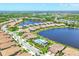 Breathtaking aerial view showcasing houses bordering a lake with a community pool area and green surroundings at 21649 Avon Park Ct, Venice, FL 34293
