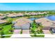Scenic lakefront home with a tile roof and verdant landscaping at 21649 Avon Park Ct, Venice, FL 34293