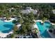 Aerial view of community pools with cabanas and palm trees, showcasing the recreational amenities and the surrounding neighborhood at 21649 Avon Park Ct, Venice, FL 34293