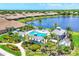 Gorgeous pool area with sun loungers, cabanas, jacuzzi, and lush tropical landscaping, overlooking a serene lake at 21649 Avon Park Ct, Venice, FL 34293
