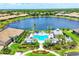 Aerial view of luxurious pool and patio area, complete with lush landscaping and tranquil lake view at 21649 Avon Park Ct, Venice, FL 34293