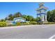 Community entrance sign featuring attractive landscaping, stone accents, and a welcoming architectural tower at 21649 Avon Park Ct, Venice, FL 34293