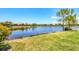 Scenic lake view with lush green grass and vibrant foliage in a well-maintained community at 21649 Avon Park Ct, Venice, FL 34293