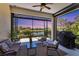 Relaxing screened lanai with comfortable seating, BBQ grill, and beautiful lake views at sunset at 21649 Avon Park Ct, Venice, FL 34293