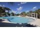 Resort-style community pool featuring palm trees, a water slide, and covered seating for a relaxing outdoor experience at 21649 Avon Park Ct, Venice, FL 34293