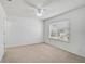 Carpeted bedroom with a ceiling fan, closet, and window providing natural light at 233 Cape Harbour Loop # 107, Bradenton, FL 34212