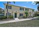 Well-maintained, two-story townhouse featuring a green door, dark shutters, and lush landscaping at 233 Cape Harbour Loop # 107, Bradenton, FL 34212