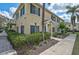 Two-story townhouse with lush landscaping, sidewalk, and tropical palm trees at 233 Cape Harbour Loop # 107, Bradenton, FL 34212