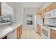 A functional kitchen featuring white appliances, tile floors, and wood cabinets at 233 Cape Harbour Loop # 107, Bradenton, FL 34212