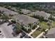 Aerial view of well-maintained townhomes featuring lush landscaping, palm trees, and ample parking at 233 Cape Harbour Loop # 107, Bradenton, FL 34212