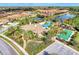 A beautiful aerial view showcases the community center, pool, tennis and bocce ball courts, and lake at 241 Marcheno Way, Nokomis, FL 34275
