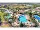 Aerial view of community pool, hot tub, bocce ball, and tennis court amidst lush landscaping at 241 Marcheno Way, Nokomis, FL 34275