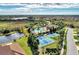 A high angle view showcases the community pool, tennis courts, and beautiful landscaping around the lake at 241 Marcheno Way, Nokomis, FL 34275