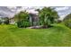 Scenic backyard featuring green lawn, mature trees, and a charming screened-in lanai at 241 Marcheno Way, Nokomis, FL 34275
