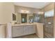 Bathroom featuring double sinks, a large mirror, modern lighting, and glass enclosed shower at 241 Marcheno Way, Nokomis, FL 34275