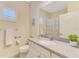 Bright bathroom with granite counters, a decorative mirror, and tiled shower with a modern shower curtain at 241 Marcheno Way, Nokomis, FL 34275