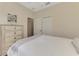 Comfortable bedroom features neutral decor, closet, and a charming dresser with decorative accents at 241 Marcheno Way, Nokomis, FL 34275