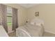 Cozy bedroom features tile floor, a beautiful bed frame, and natural light from the exterior window at 241 Marcheno Way, Nokomis, FL 34275