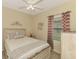 Inviting bedroom featuring a cozy bed, side table, and window with patterned curtains at 241 Marcheno Way, Nokomis, FL 34275