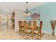 Bright dining room features a wooden table with seating for six, a decorative chandelier, and serene wall color at 241 Marcheno Way, Nokomis, FL 34275